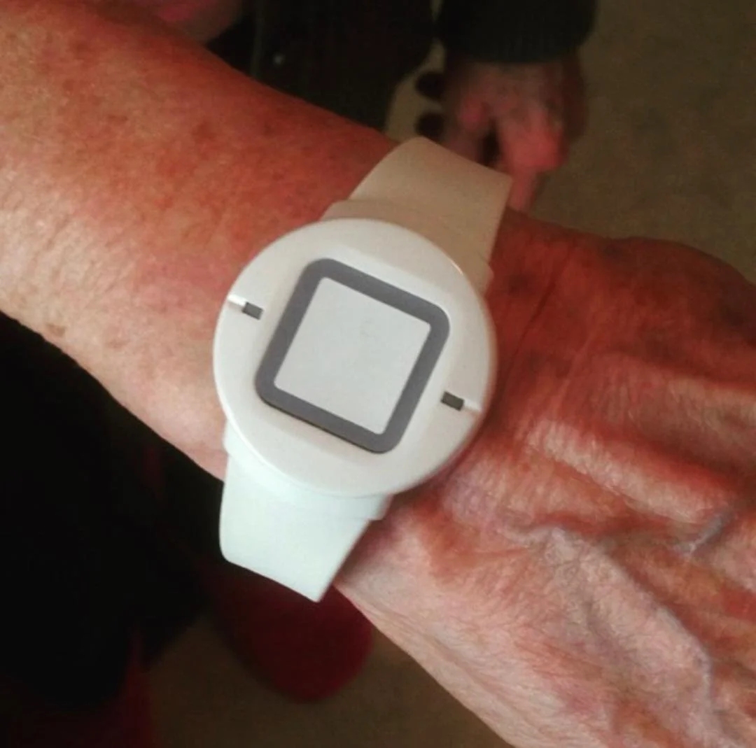 Older adult wearing a medical alert pendant on the wrist